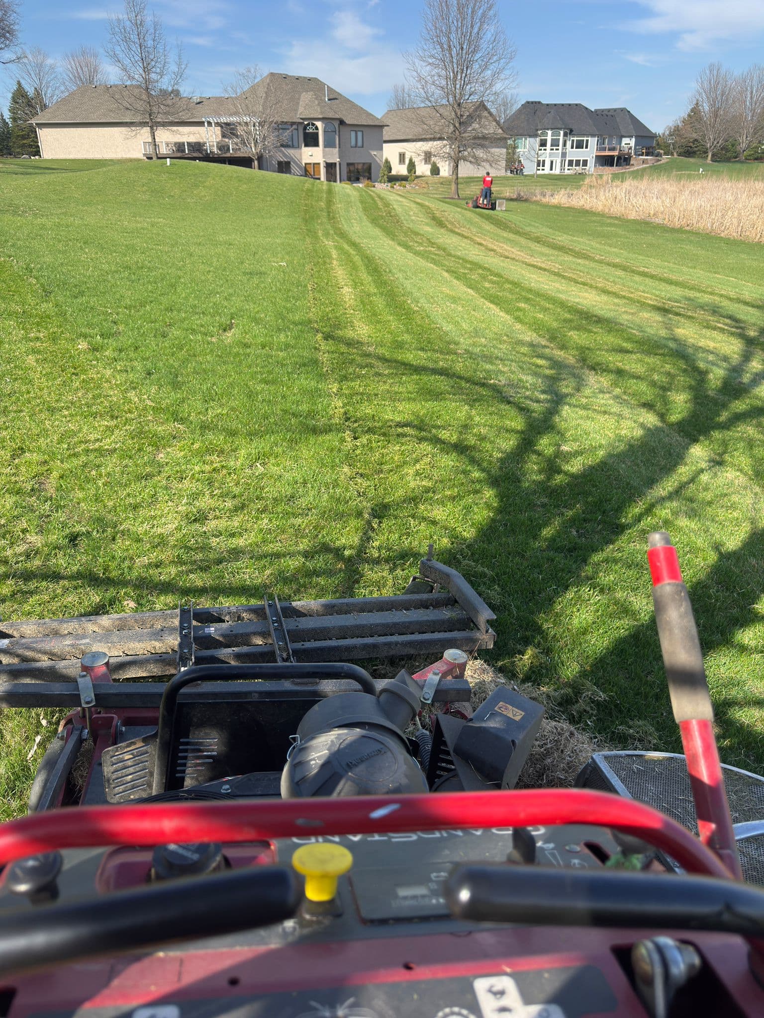 A MowStandard professional mower working on a lawn with even stripes
